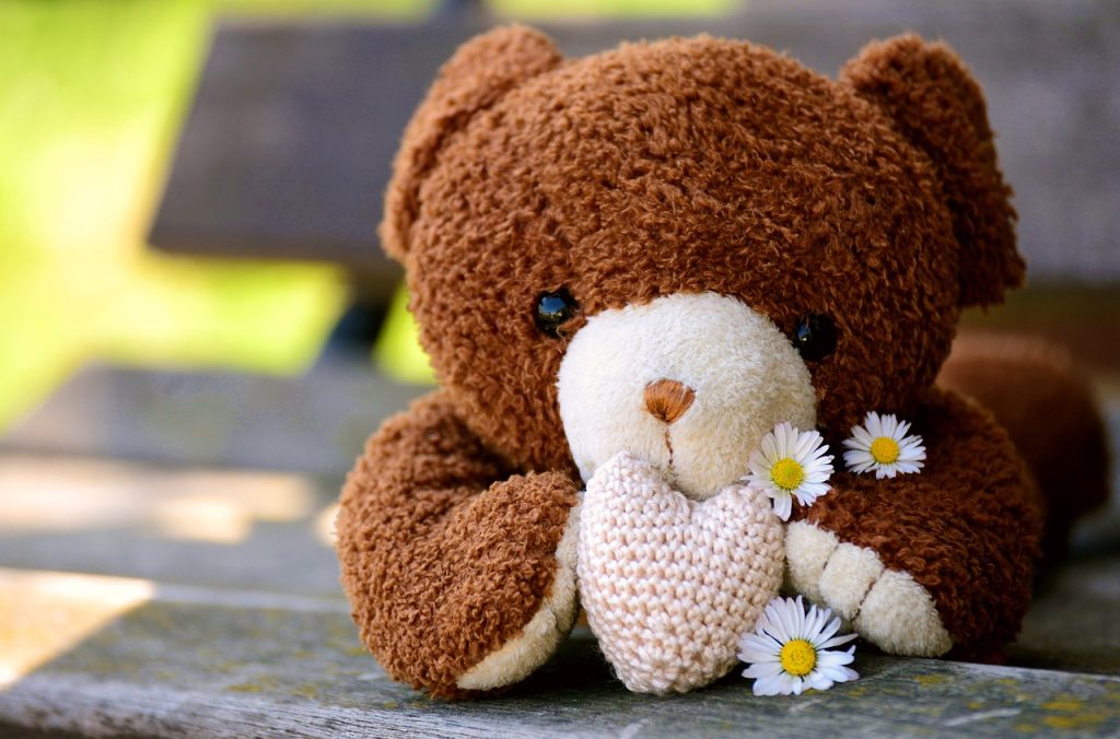 ハートと花をもったクマのぬいぐるみ