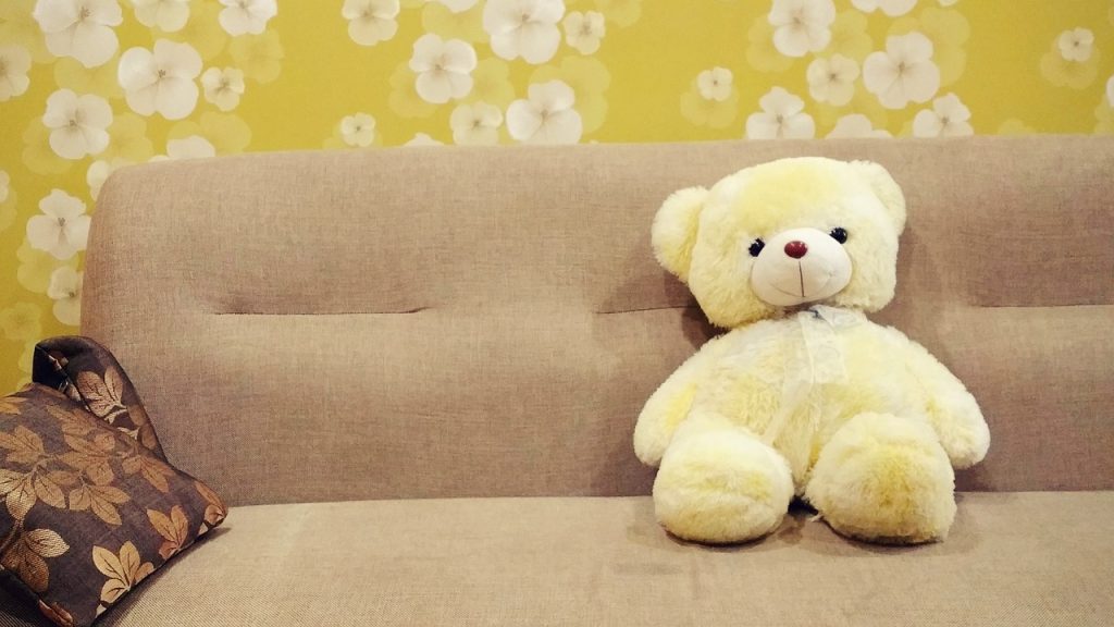 自宅のソファでくつろぐクマのぬいぐるみ